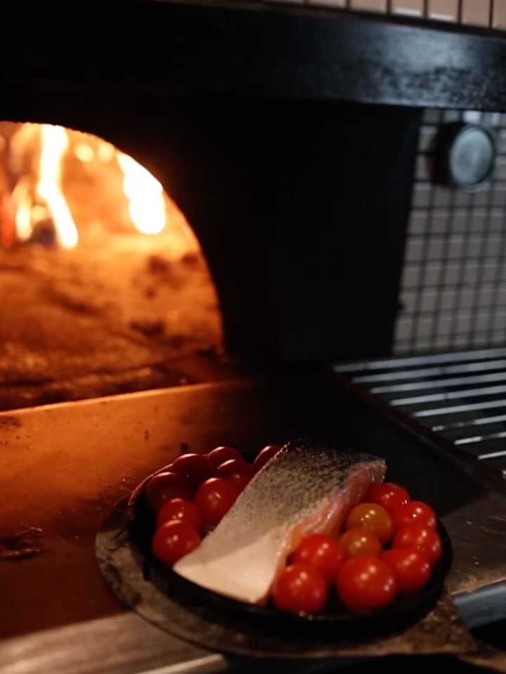 Salmón al horno de leña. Lo asamos con tomates cherry de nuestra huerta ecológica y un pesto fresco elaborado a diario. El horno de leña alcanza los 380º de temperatura. Eso hace que el salmón quede perfectamente asado por fuera, y muy hidratado en el interior. #roostiqbar #roostiqbarmadrid #barmadrid #roostiq